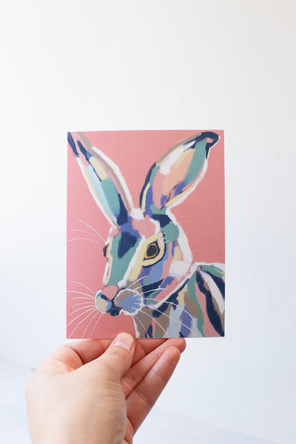 A abstract colored bunny on a pink background greeting card on textured paper.