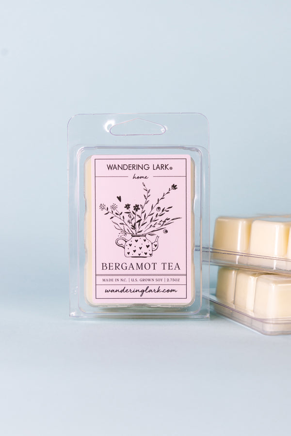Bergamot Tea Soy Wax Melts in a plastic container with a lavender label with an illustration of a teapot with flowers coming out of it.